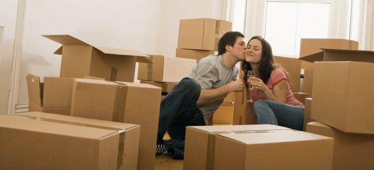 Romantic couple with champagne and moving boxes