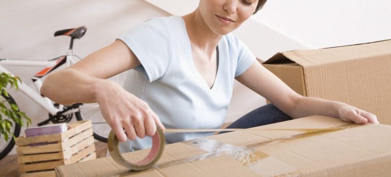 Woman taping moving boxes