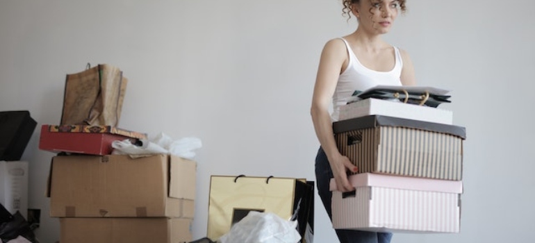 Una mujer cargando cajas para el traslado de